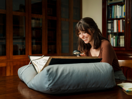 A researcher examines a book